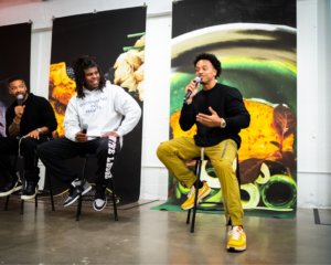 Three authors of Black Power Kitchen sitting on stools in gallery giving interview.