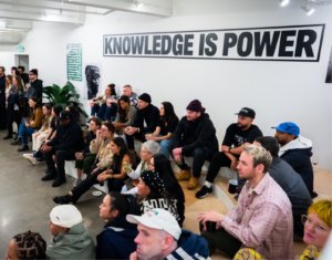 Knowledge is Power sign above crowd watching Ghetto Gastro authors