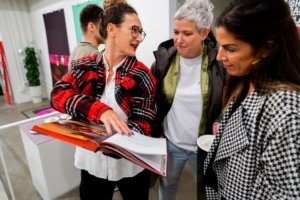Three women looking through Ghetto Gastro book