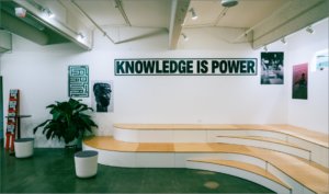 stadium seating in gallery where wall reads Knowledge is power.
