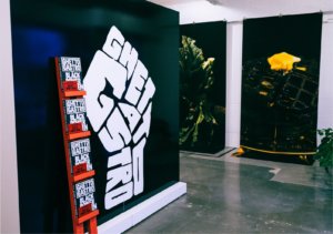 Wall with Ghetto Gastro fist logo with book display