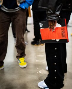 someone holding a ghetto gastro book in a group of people at event