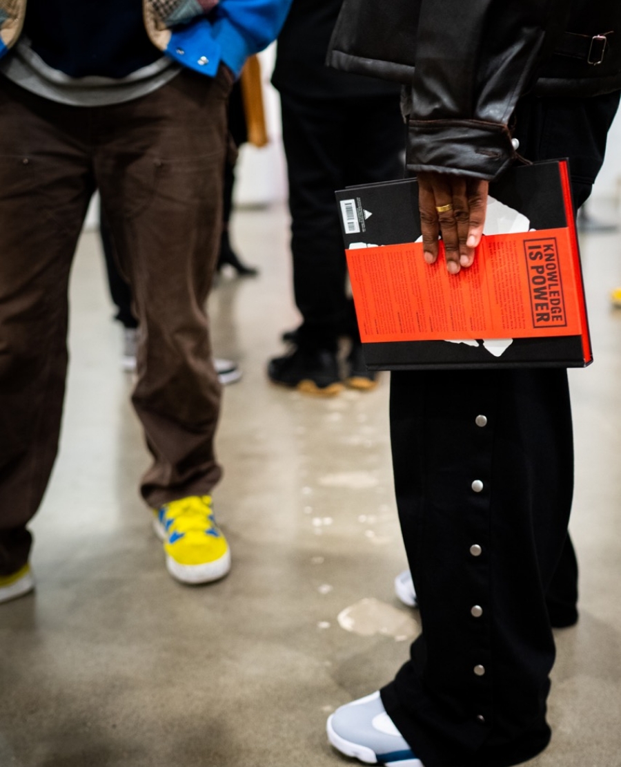 someone holding a ghetto gastro book in a group of people at event