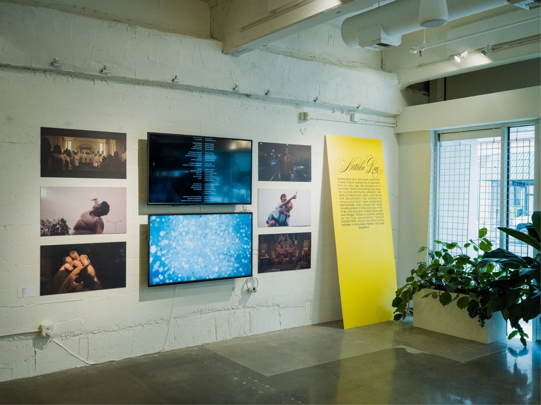 Wall showing the work of Natalie. 2 TV's and 6 video stills on white concrete wall