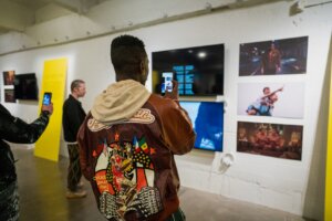 2 people take photos with their phones at gallery opening