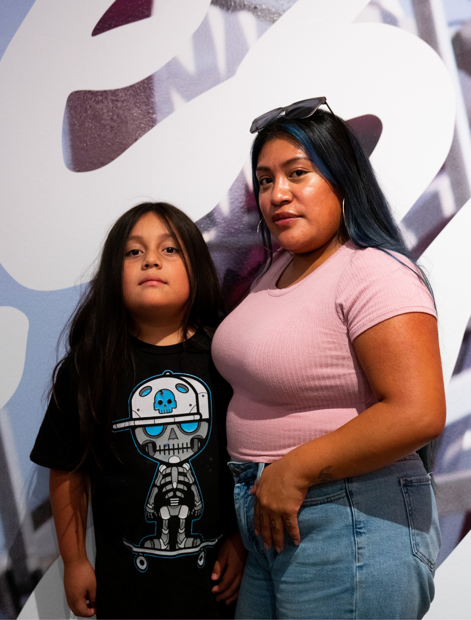 Woman and young boy pose in front of gallery wall