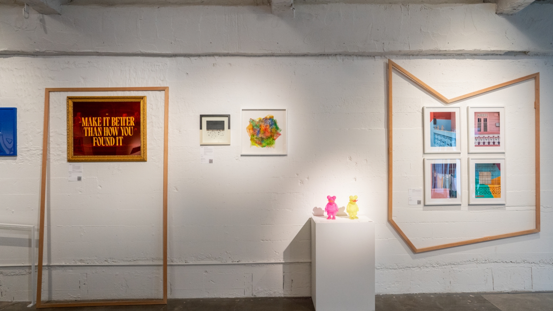 A group of framed artworks on display in an art gallery.