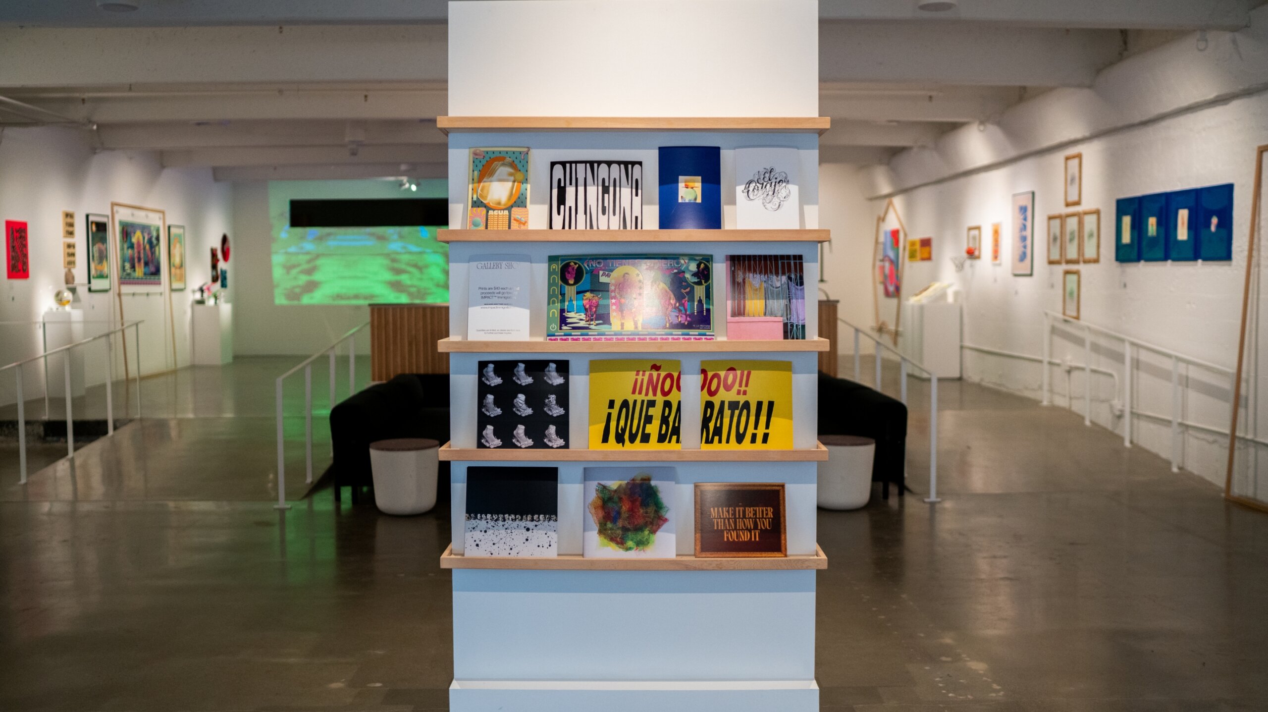 A display of prints on shelves in an art gallery.