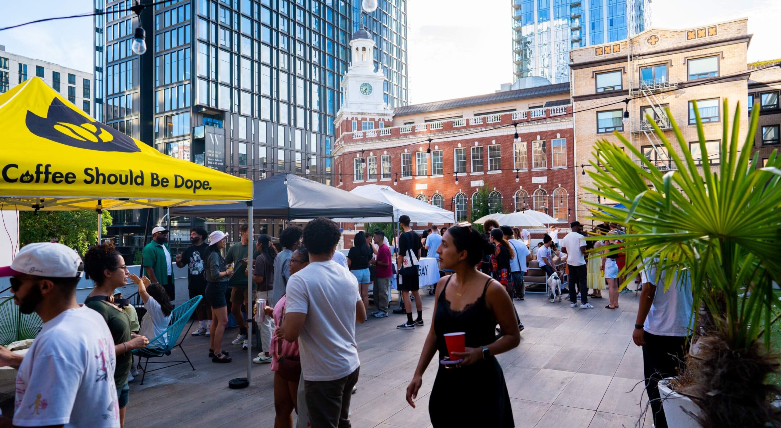 A group of people standing in front of a tent in a city.