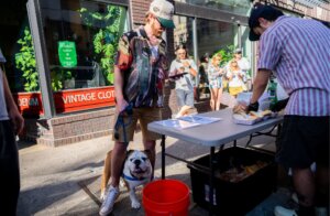 A man with a dog standing next to a table.