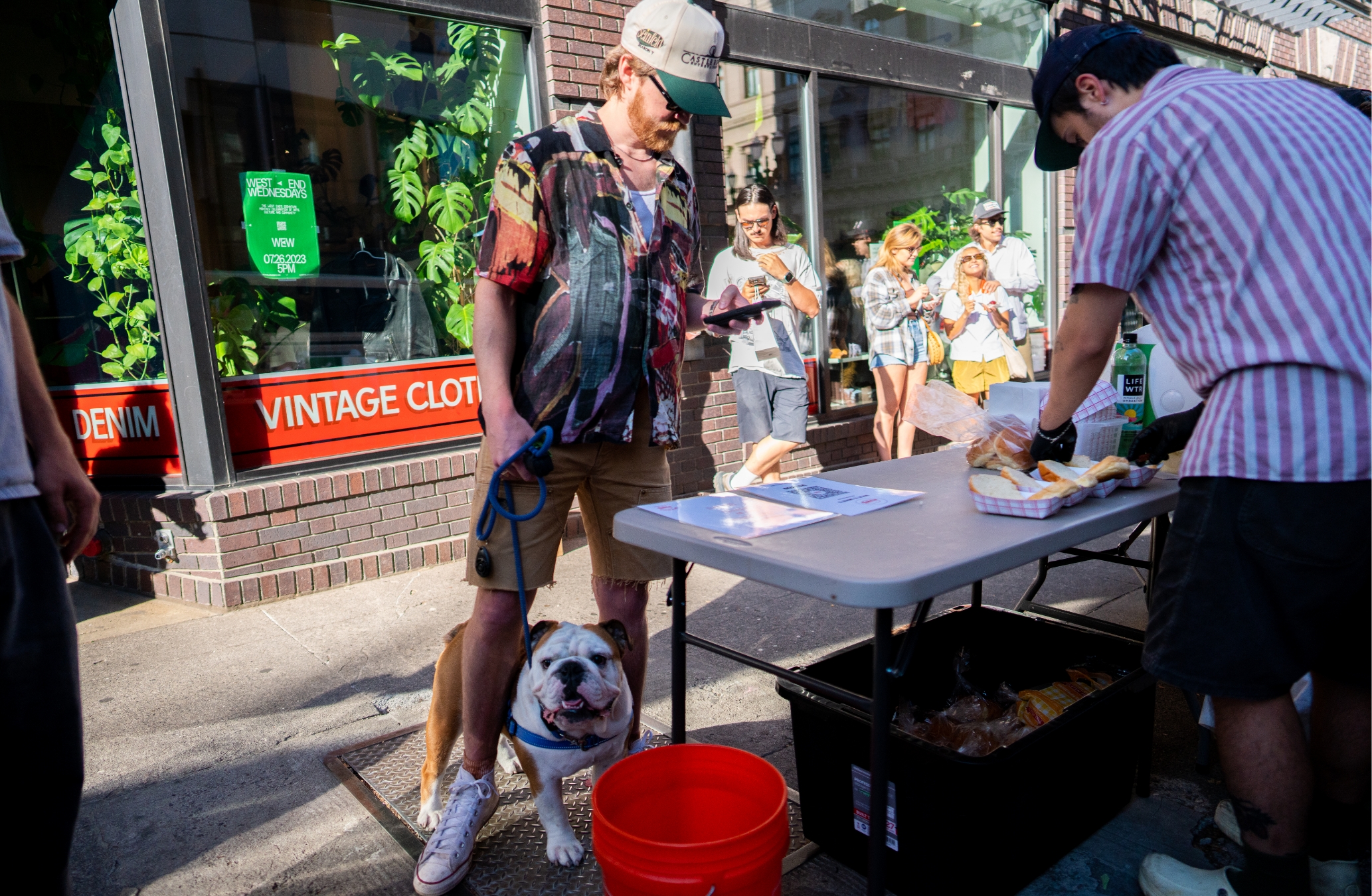 A man with a dog standing next to a table.