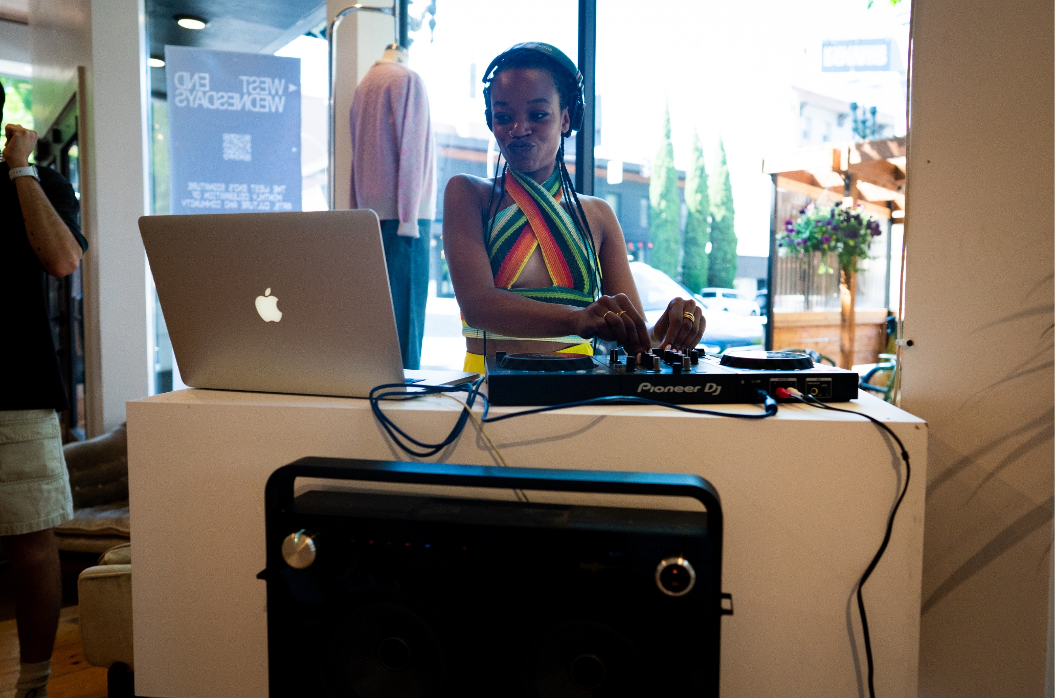 A woman is playing a dj set in a store.
