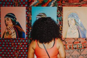Back of person's head looking at 3 paintings
