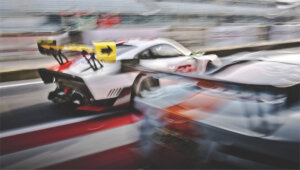 two cars racing on a track close up and blurry
