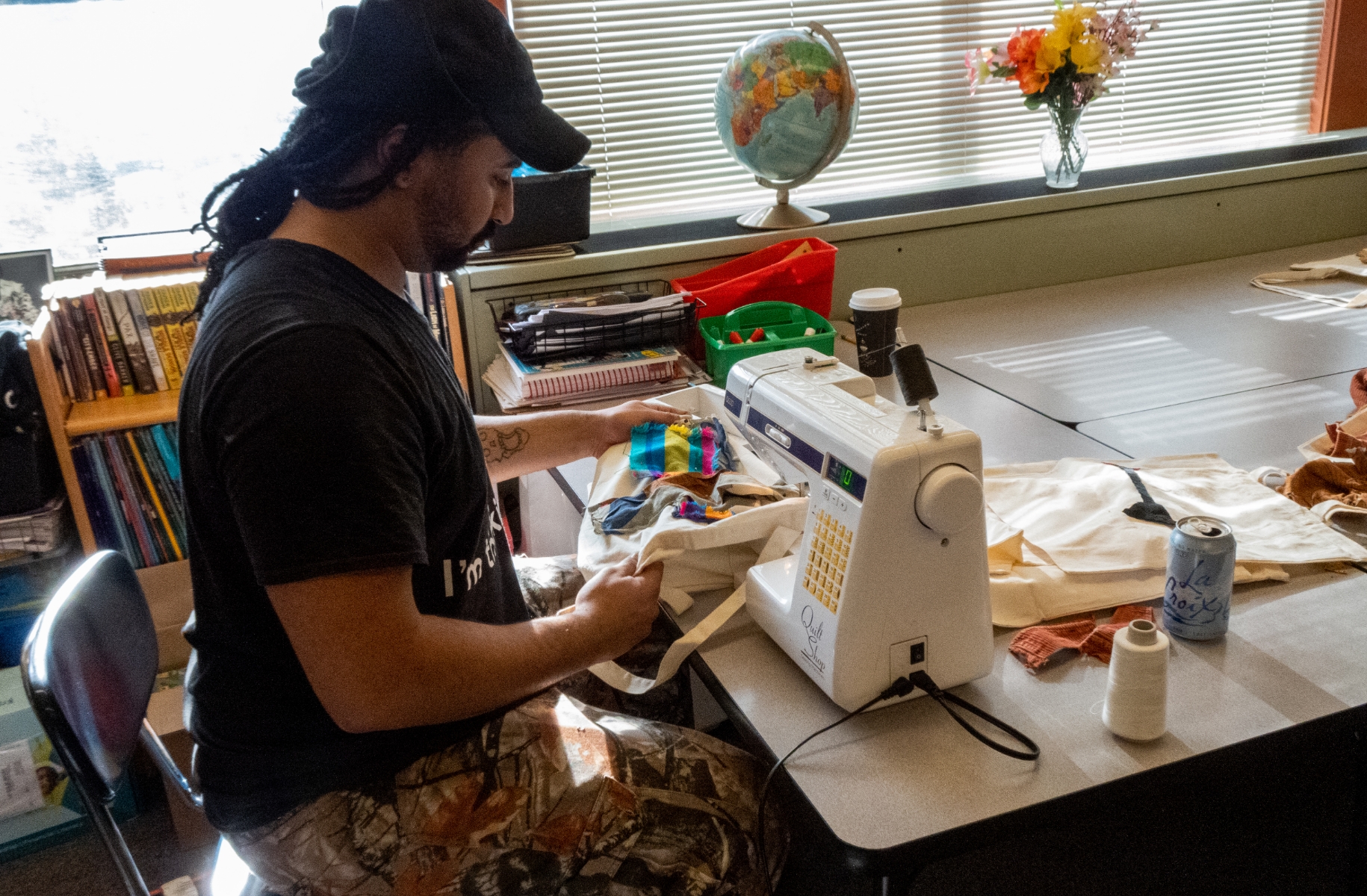 person sits at sewing machine
