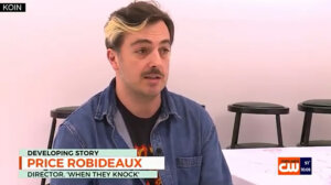 A man with a mustache and streaked hair, wearing a denim shirt, is seated indoors. On-screen text identifies him as Price Robideaux, director of "When They Knock.