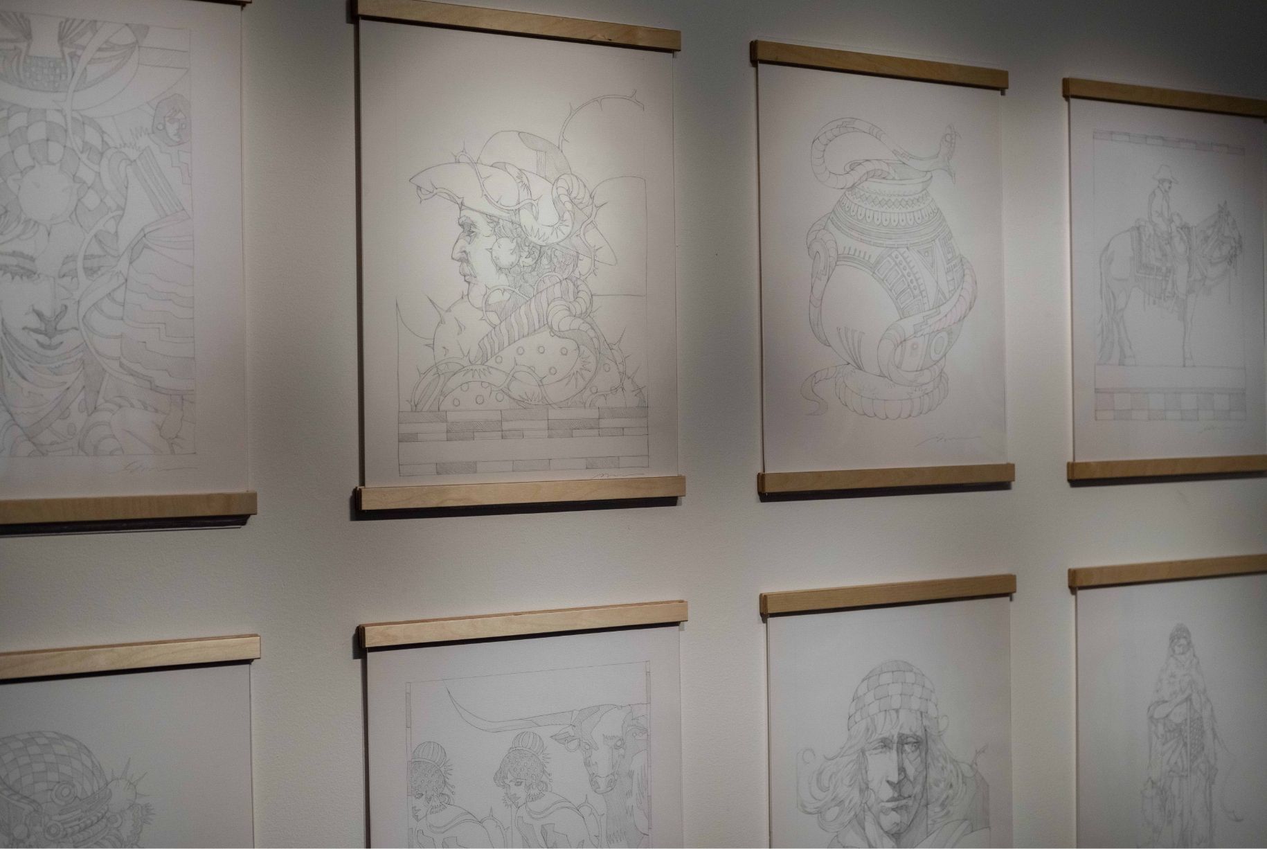 A gallery wall displaying framed pencil sketches of various medieval-themed figures and scenes.