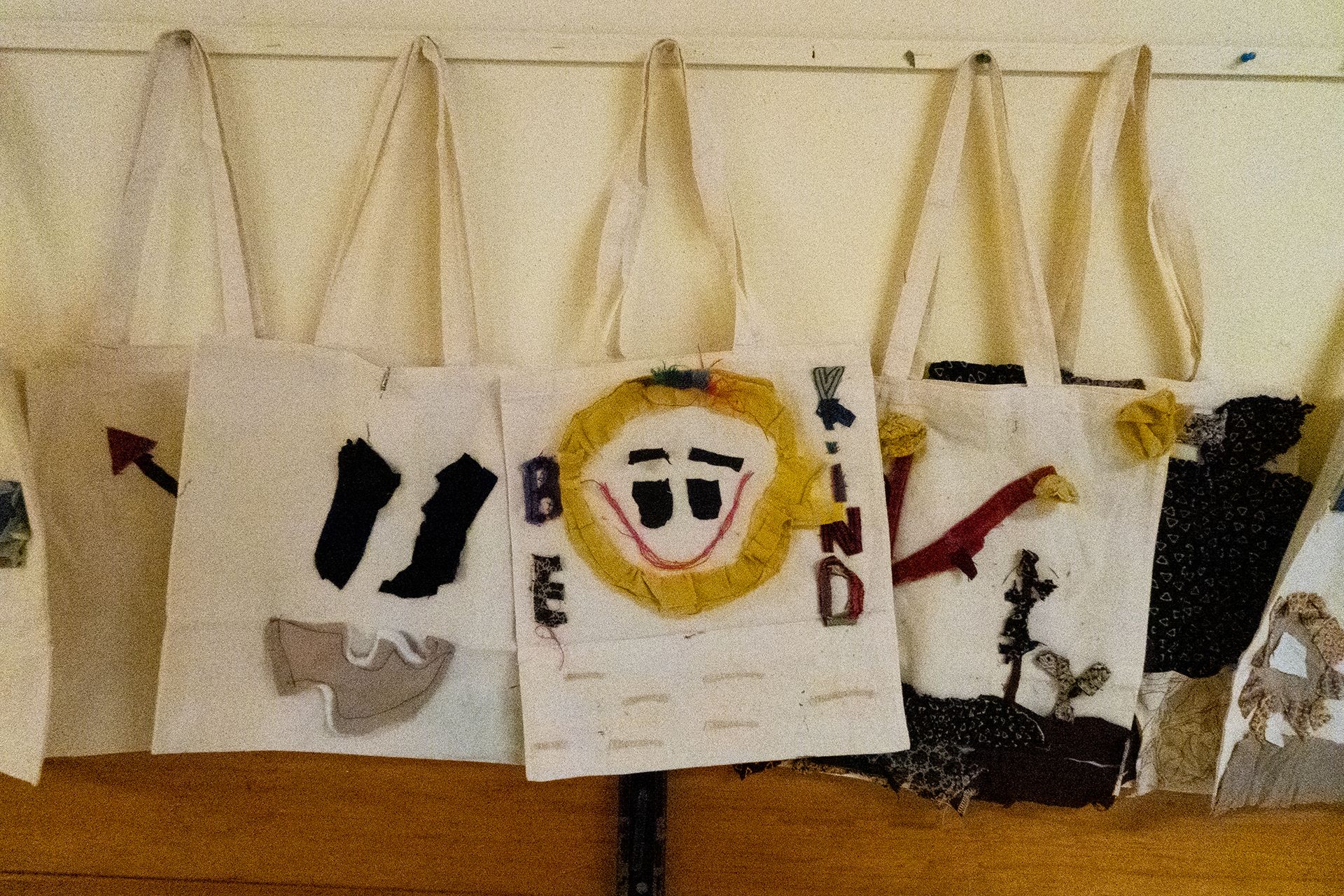 tote bags with fabric designs sewn and glued onto them