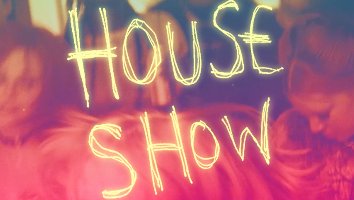 Colorful neon letters spell "HOUSE SHOW" against a blurred background.