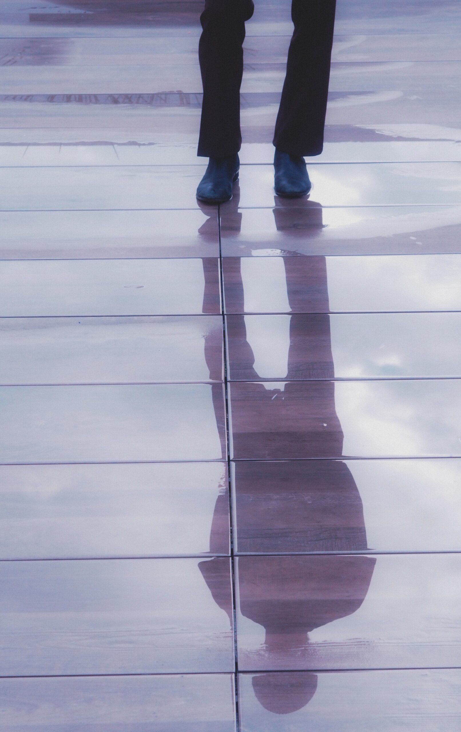feet on a rainy surface that is reflecting the rest of the body