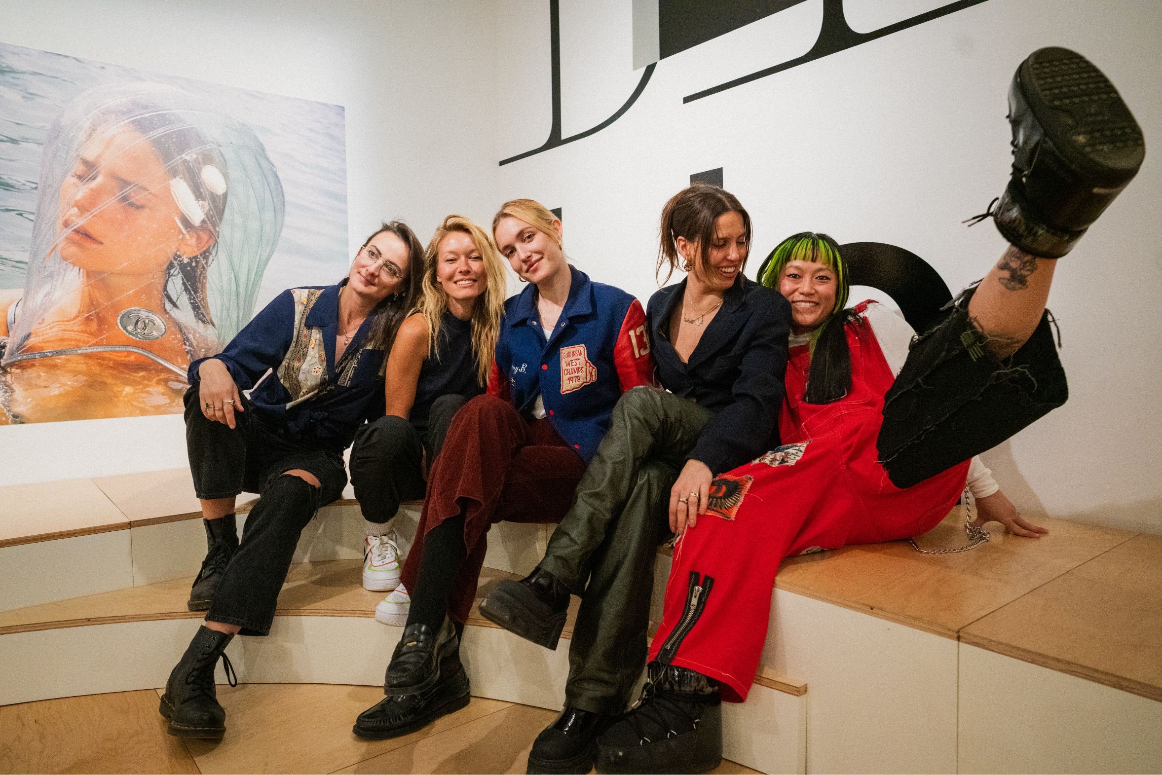 Amber, Carlotta, Christine and Natalie posing together in gallery. Smiling and Christine has her leg up.