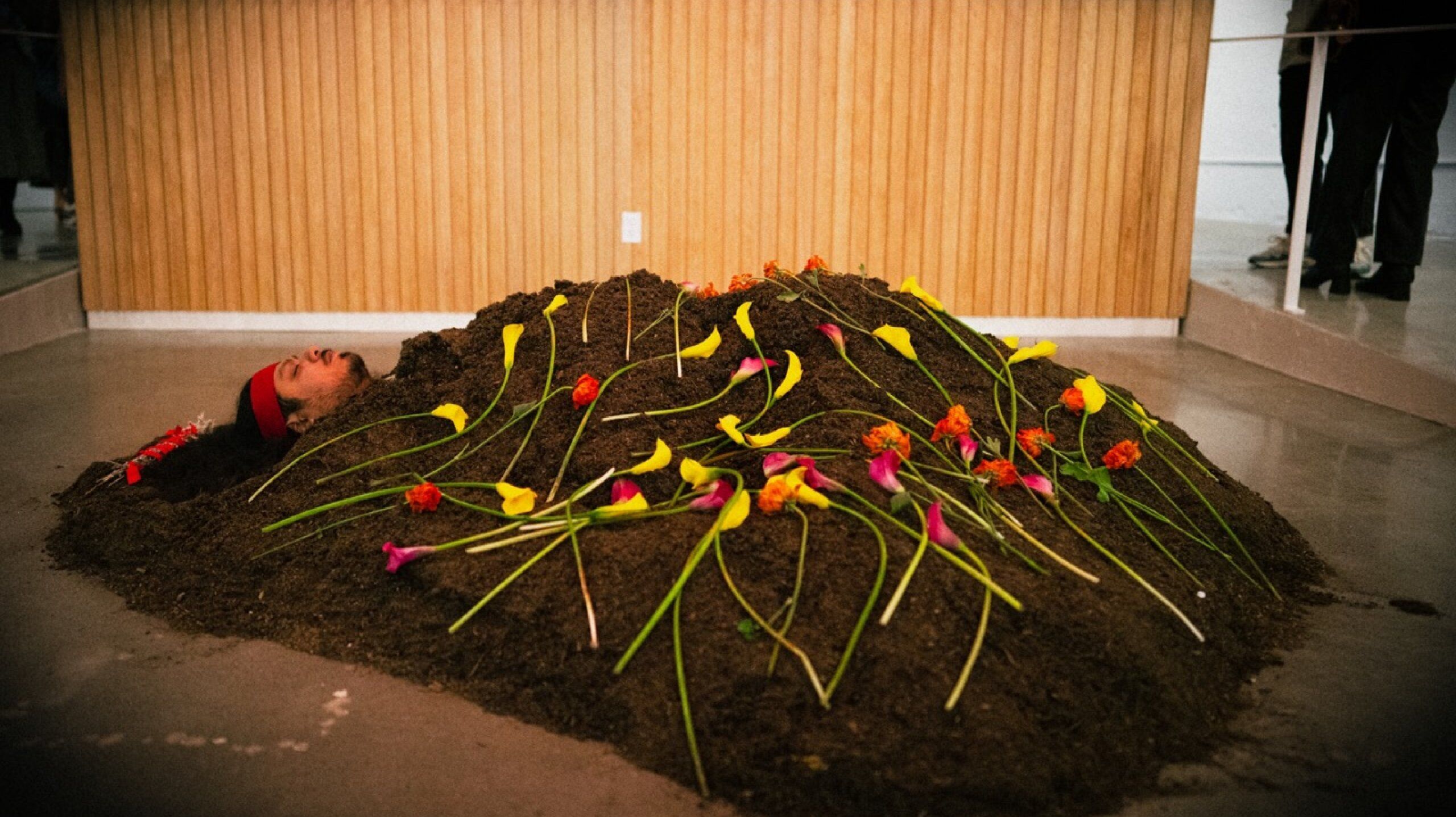 Josue buried during exhibit with flowers over the dirt