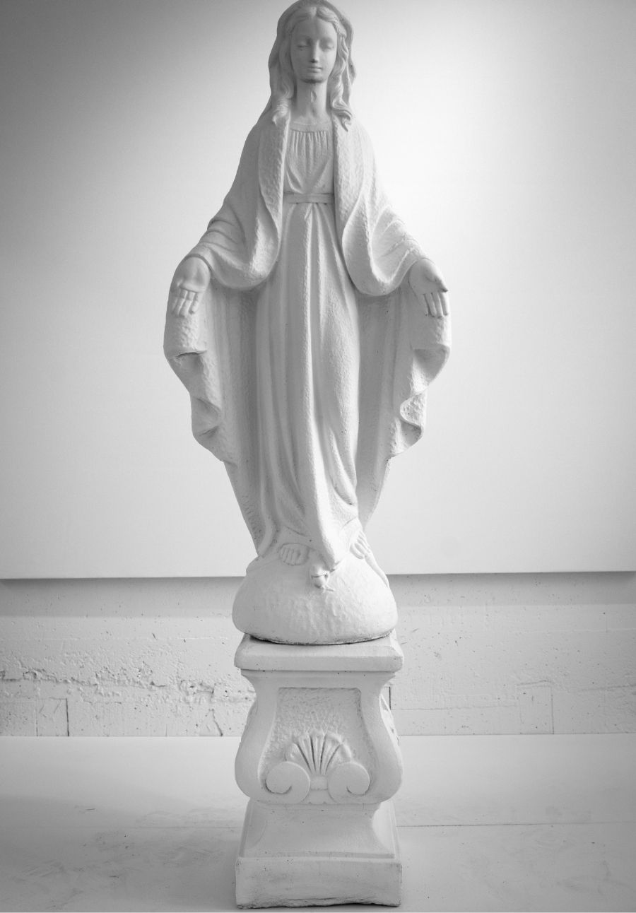 white virgin Mary statue in front of white wall