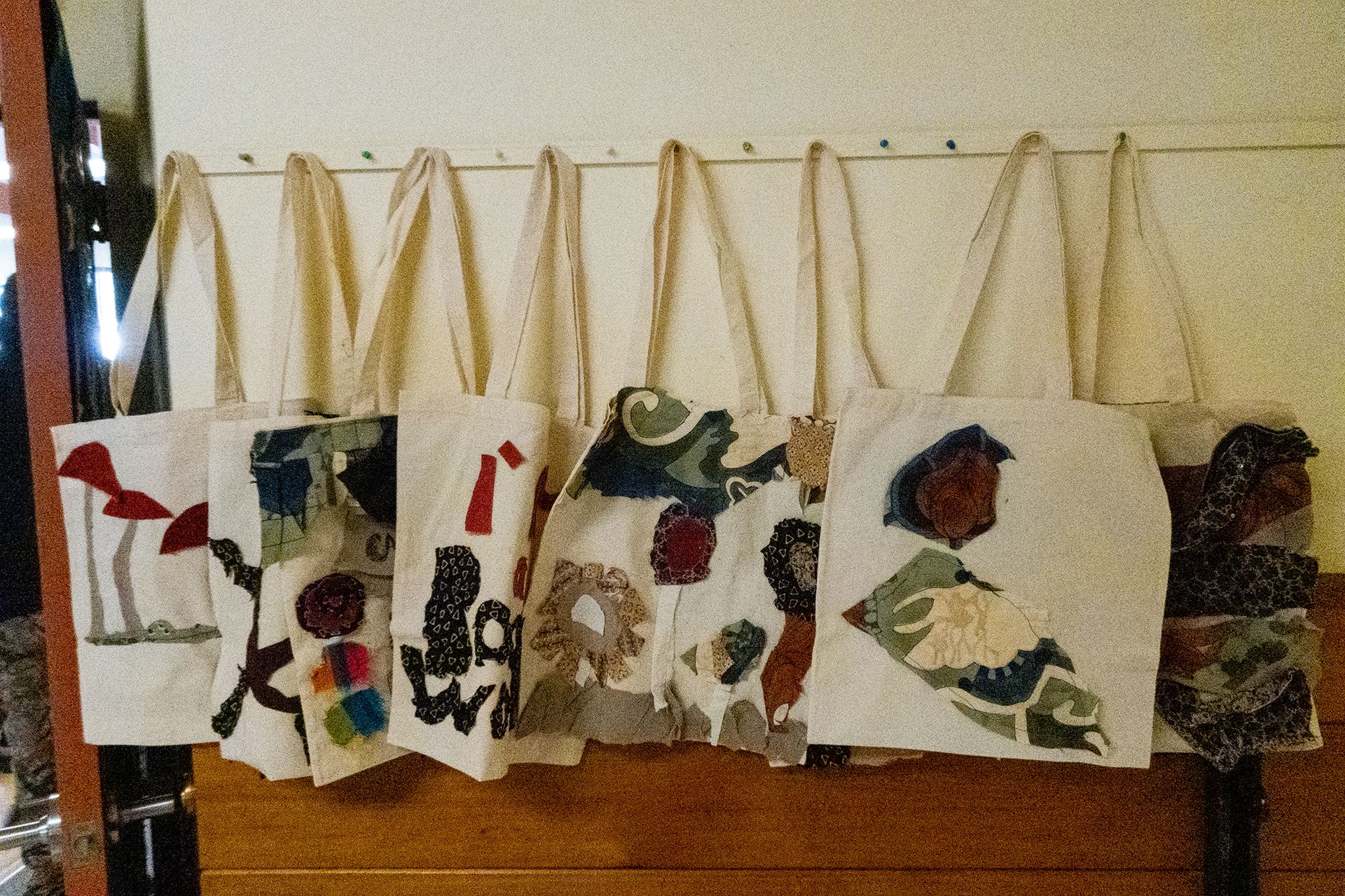 tote bags with fabric designs sewn and glued onto them