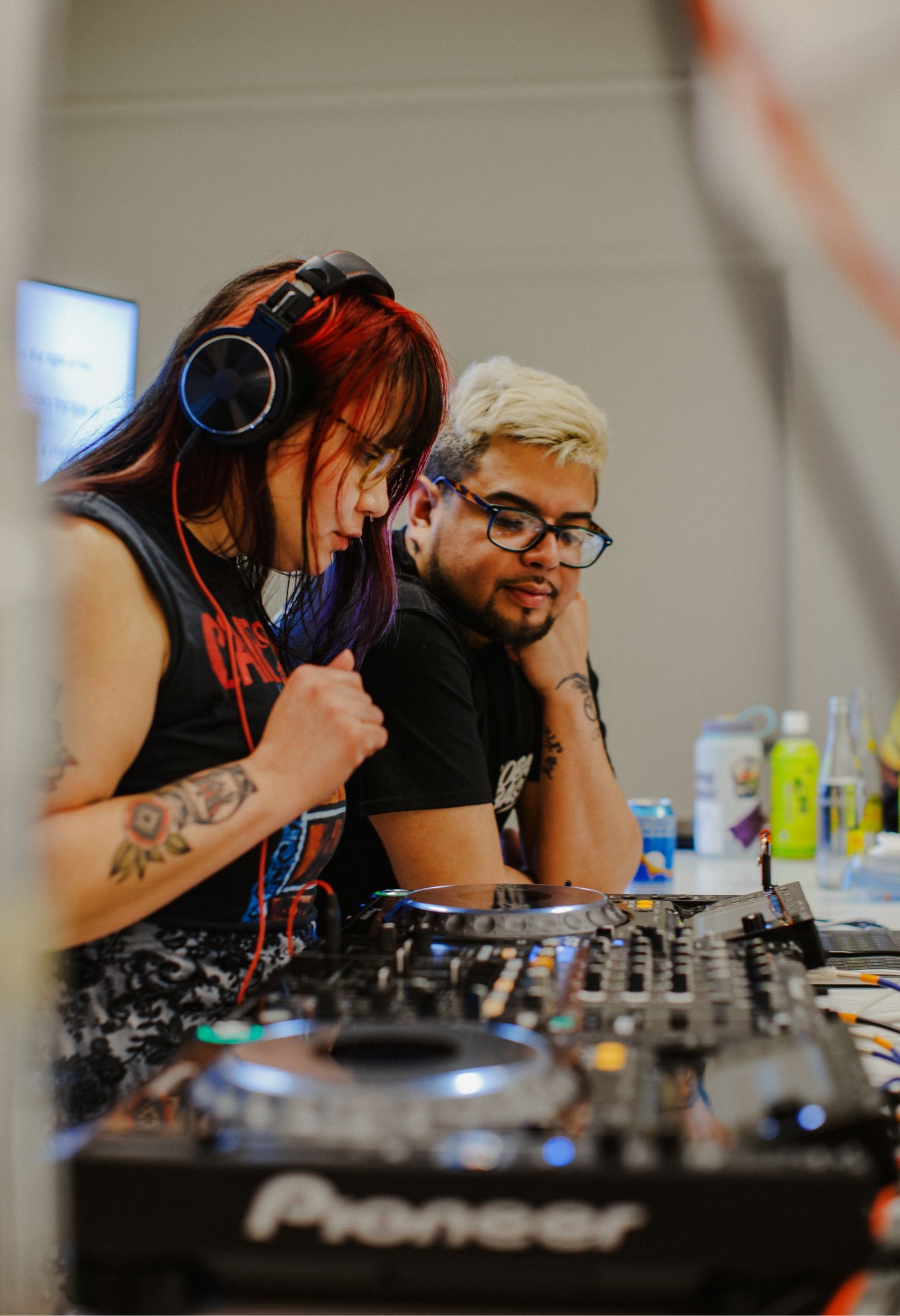 2 people behind DJ mixer set up