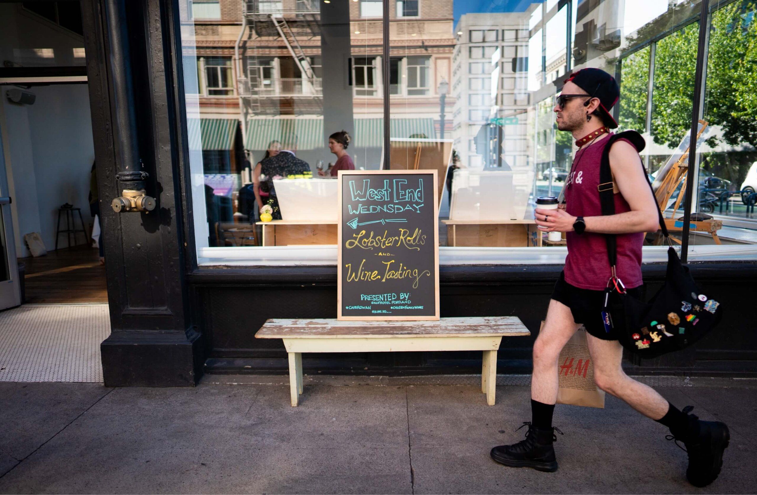 A man walks past a sign in front of a coffee shop.