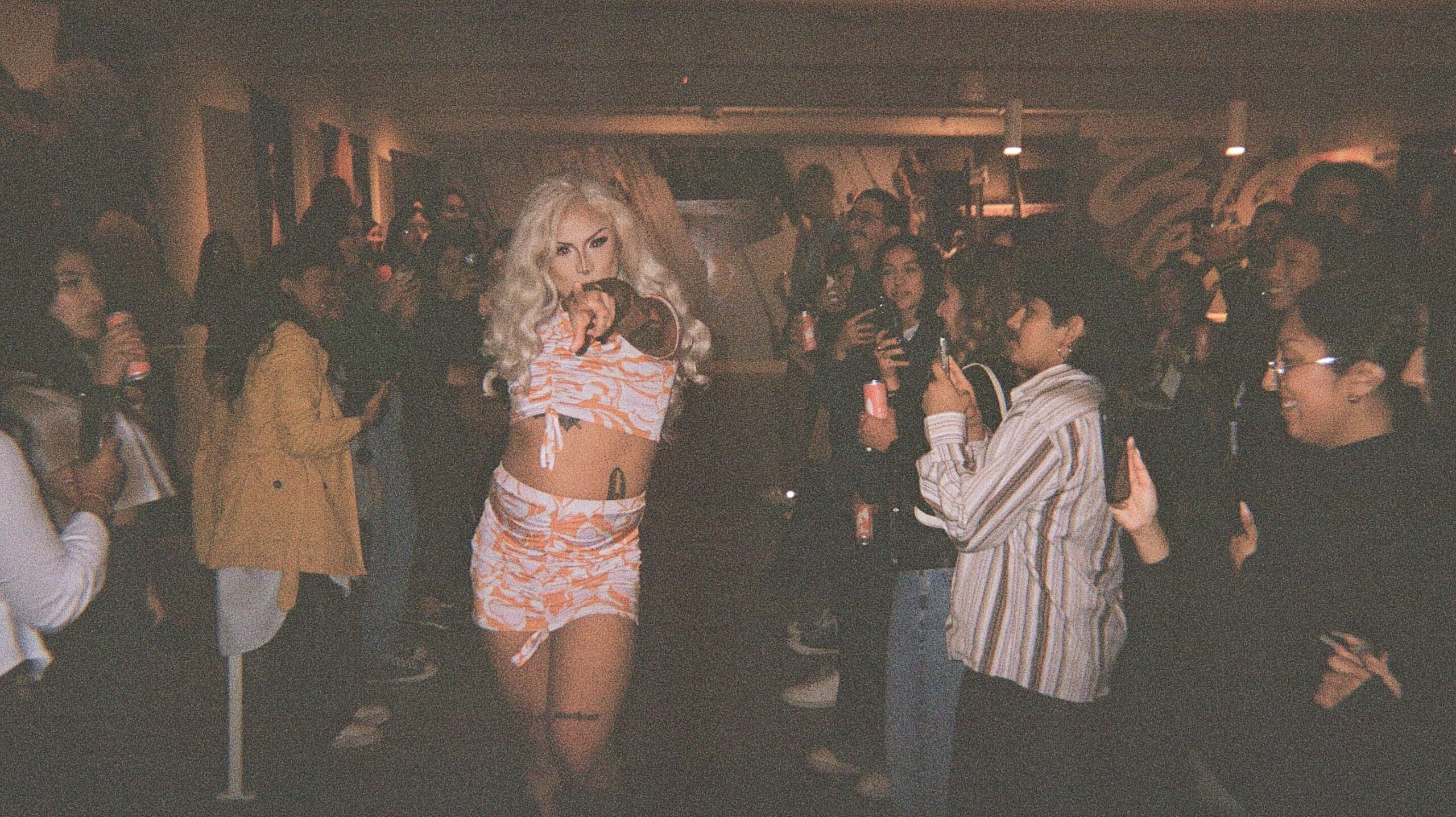 A woman is standing in front of a crowd of people.