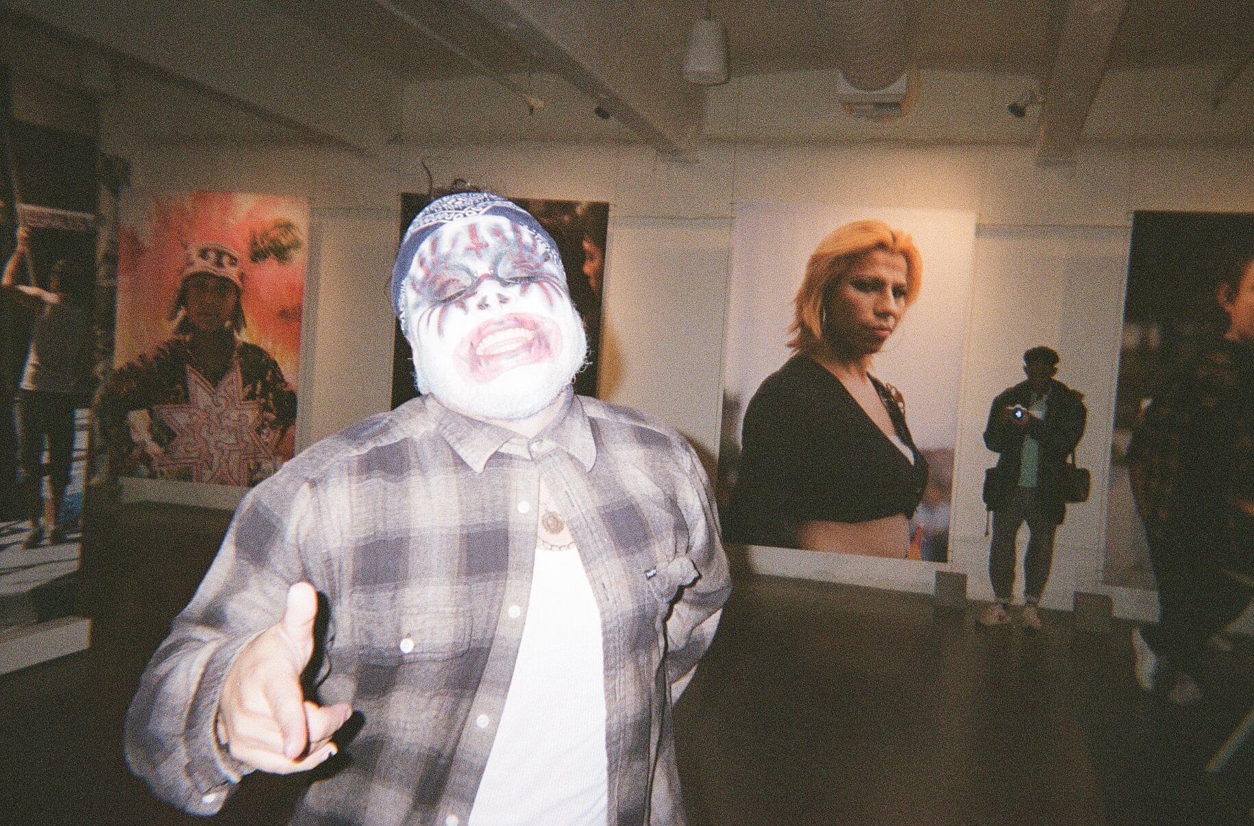A man wearing a mask in an art gallery.