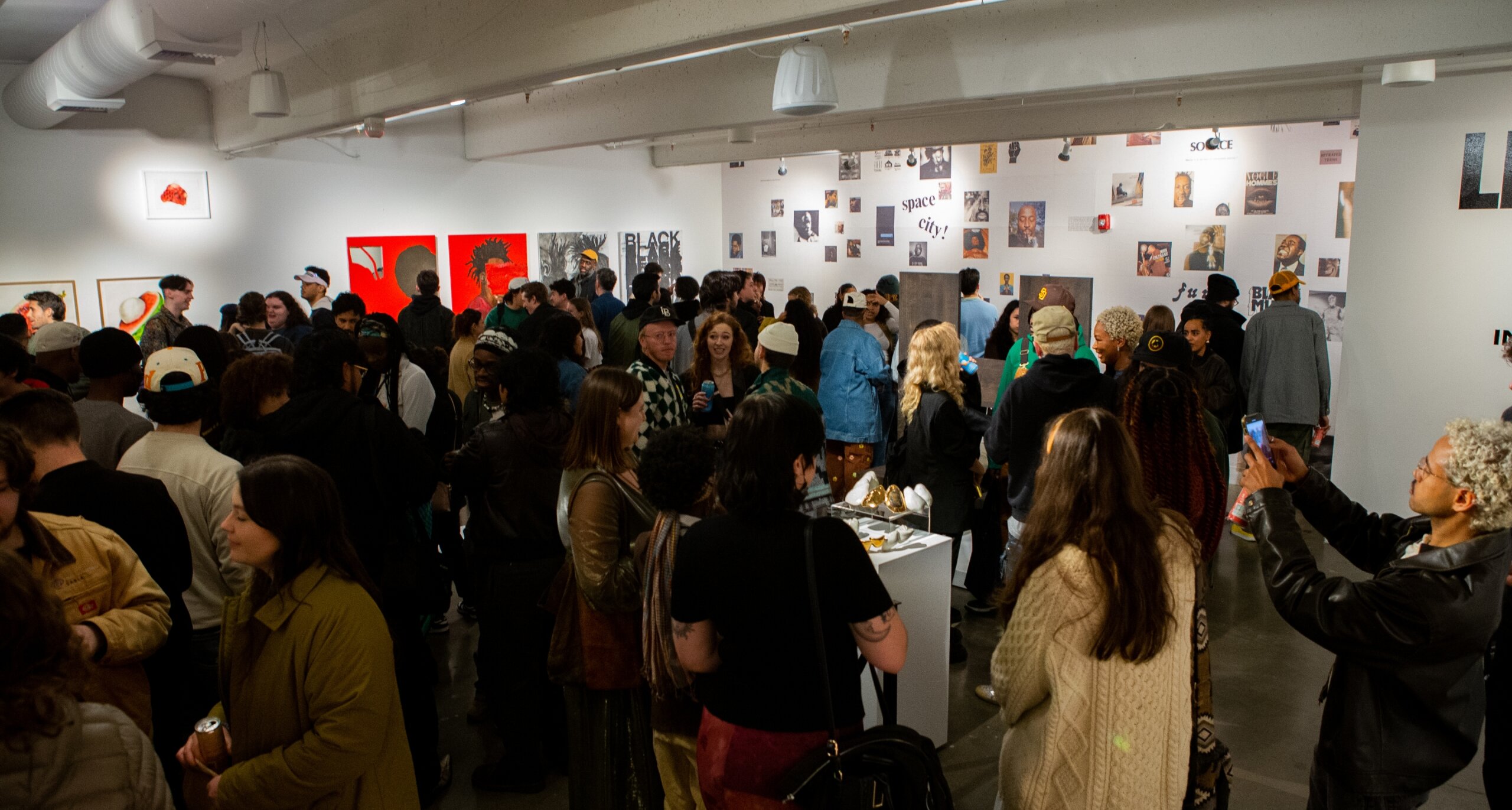 Art gallery full of people socializing and admiring art