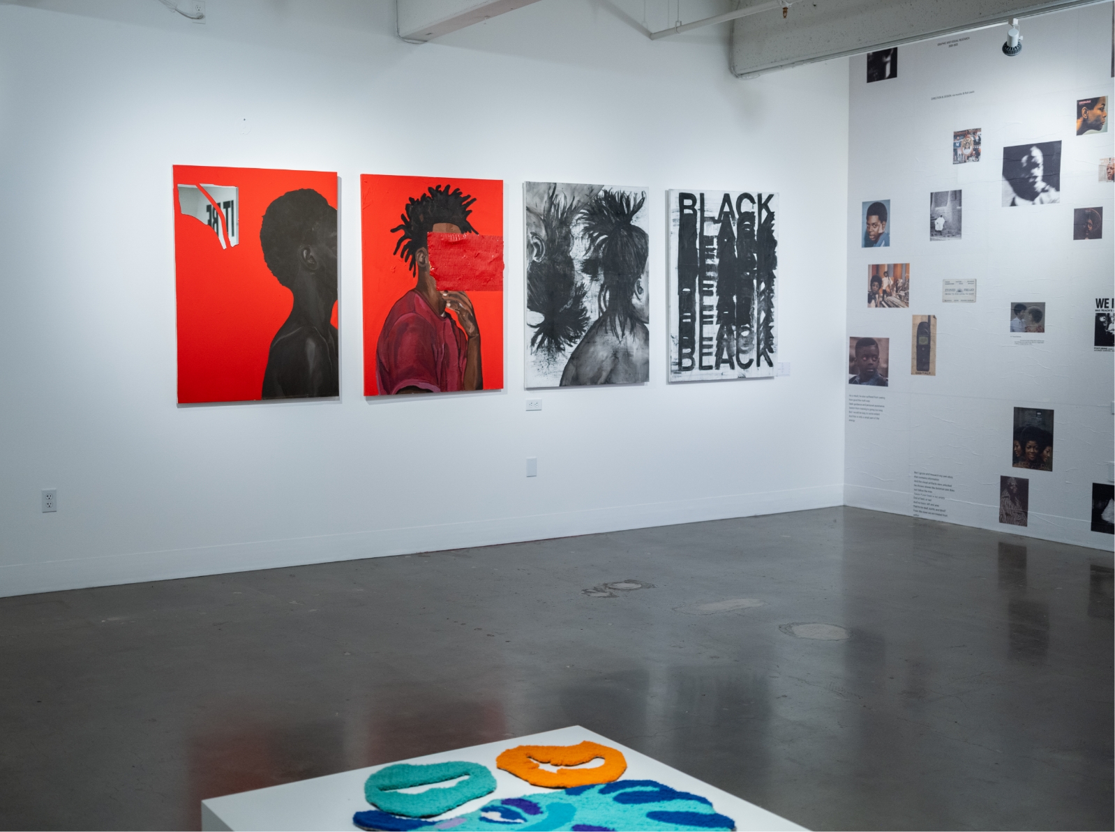 An art gallery with several paintings on the wall.