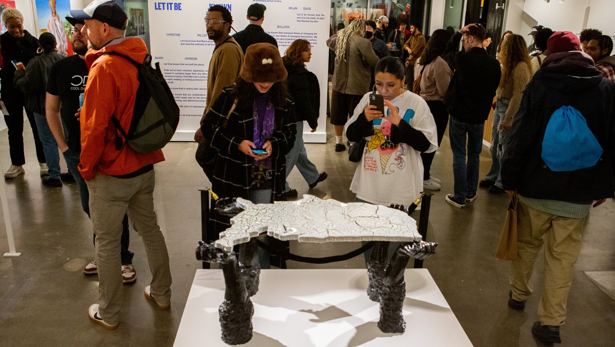 A group of people looking at a sculpture in an art gallery.