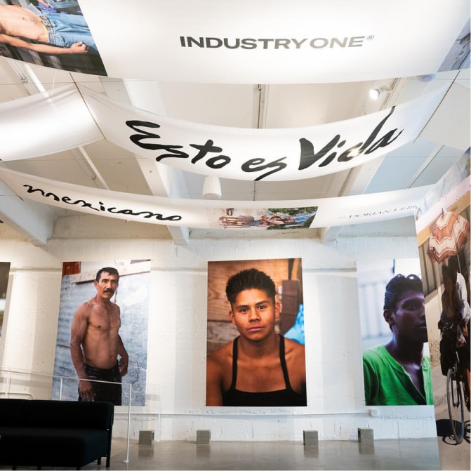 Exhibition space with hanging banners and portraits of various individuals on display.